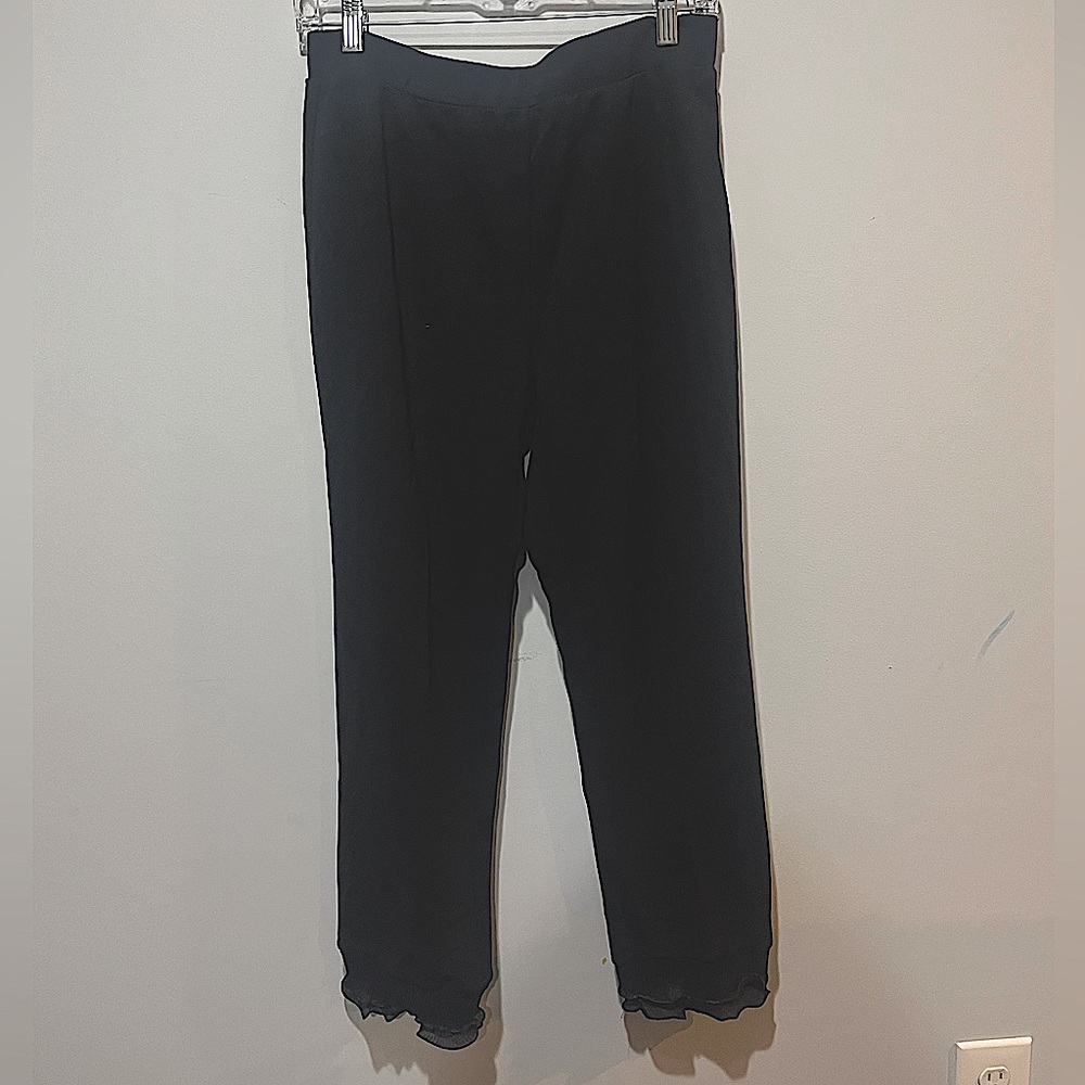 Black pants with ruffle at ankles.